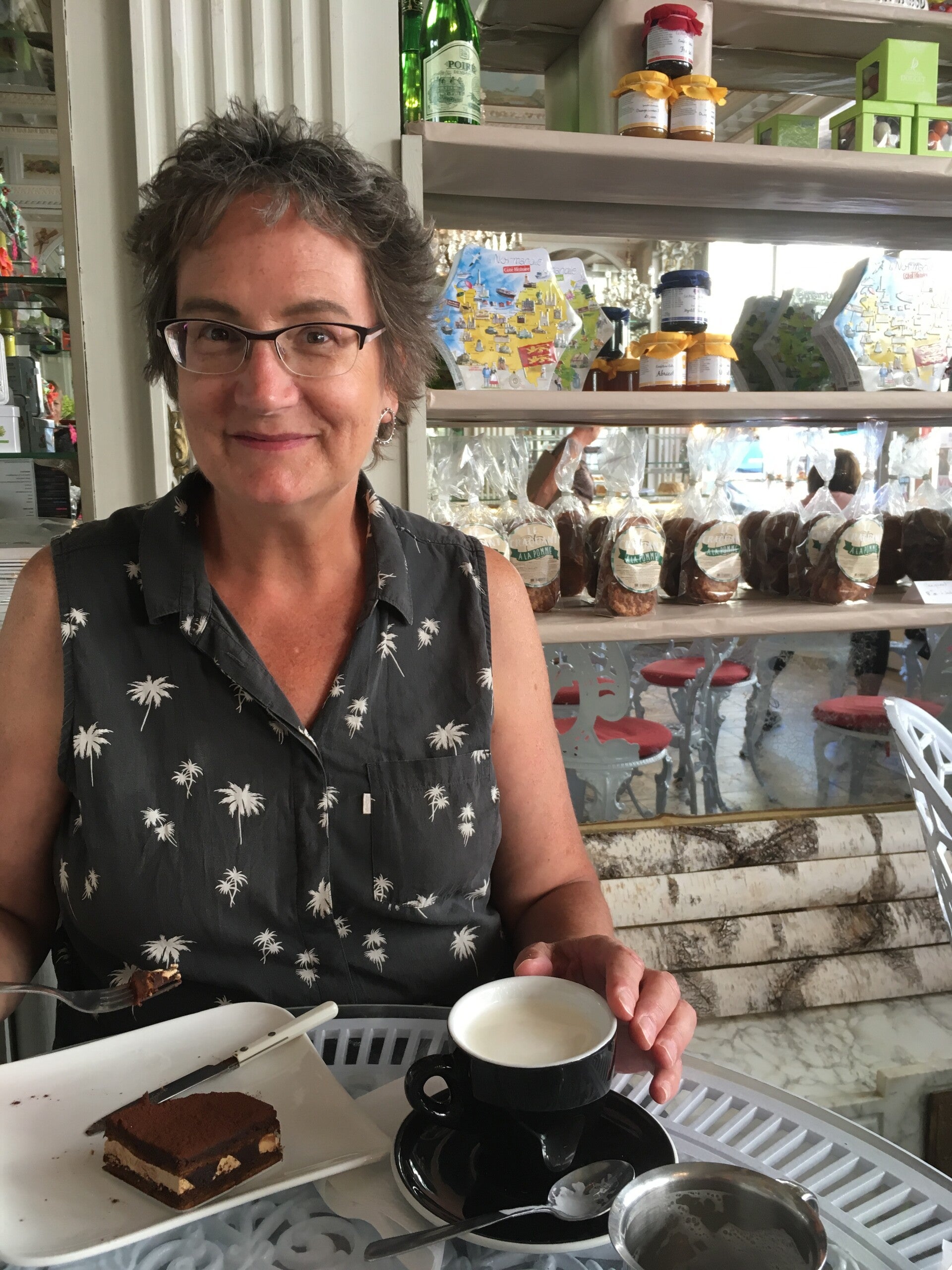 Photo of artist, Marie Banville, in cozy French cafe, enjoying a pastry and a cafe au lait. 