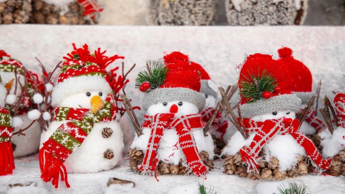 Snowbabies figurines in winter outfits enjoying each other’s company in a cozy seasonal display