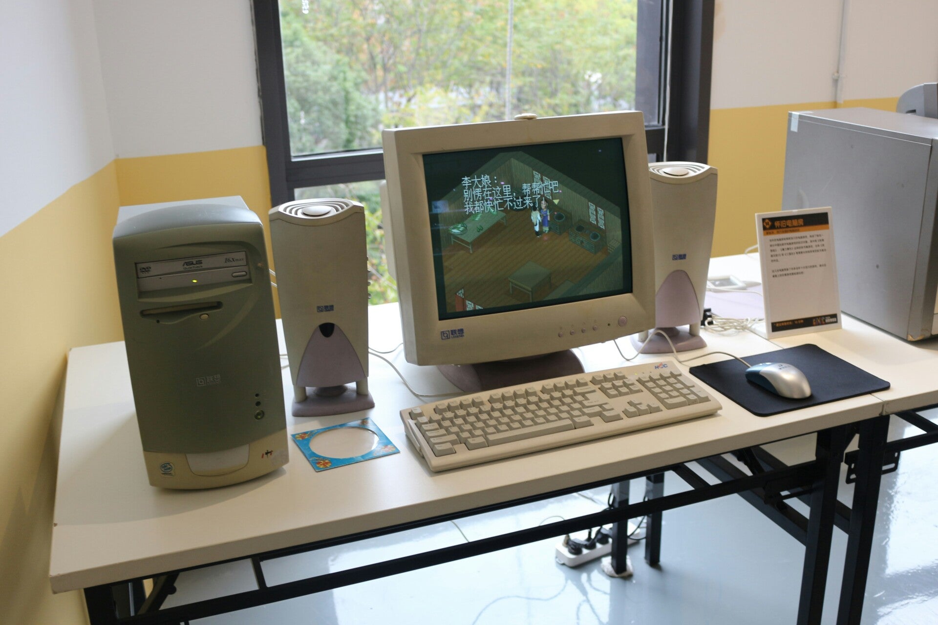 Vintage desktop computer setup with CRT monitor and speakers on a white desk.