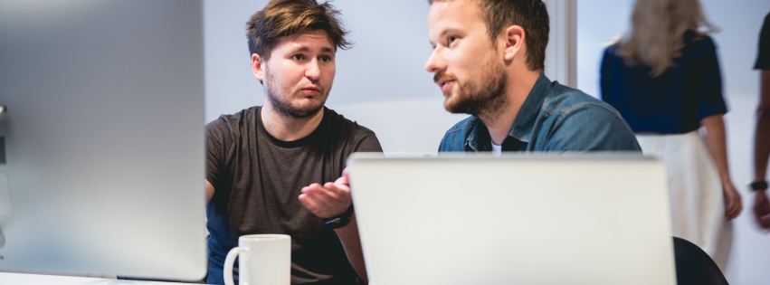 Twee collega's in gesprek op kantoor