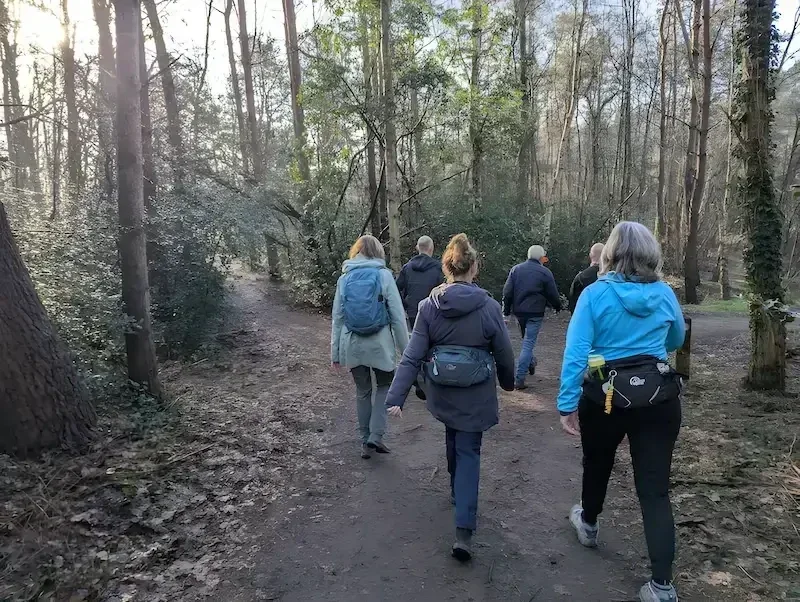 Een leuke enthousiaste groep wandelaars in het bos, bij een zeer tevreden beoordeling over de wandelroute.