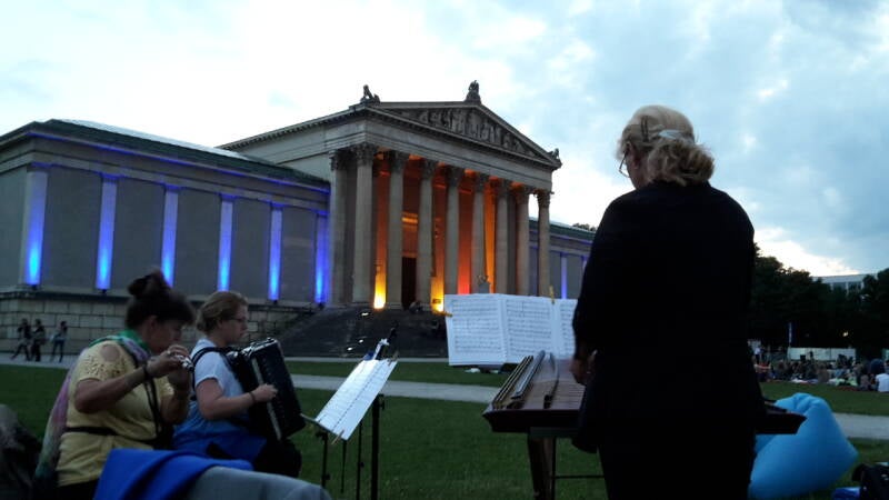 Das Trio am Könisplatz in München, im Vordergrund die Musikerinnen, im Hintergrund die Antikensammlung