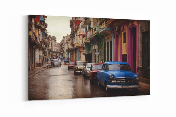 Een klassieke blauwe auto geparkeerd in een sfeervolle Cubaanse straat