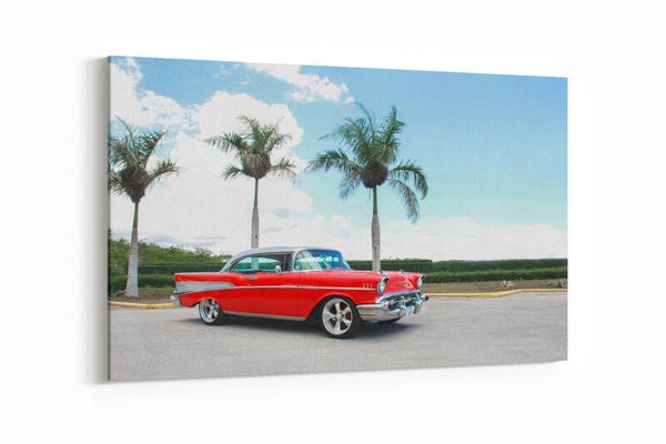 Een vintage rode Chevrolet met palmbomen op de achtergrond