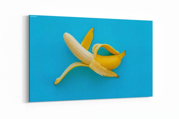 Opened banana on bright blue paper