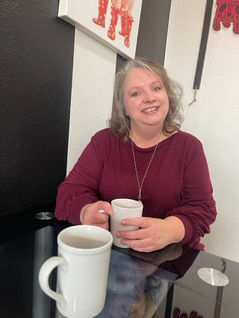Remi sitting with coffee in hand