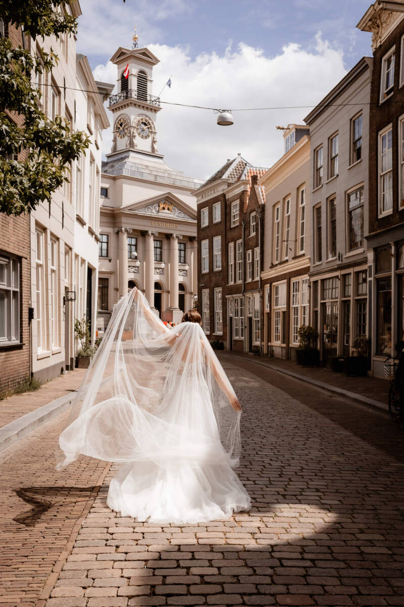 Bruidspaar loopt hand in hand door een bos na de huwelijksceremonie.