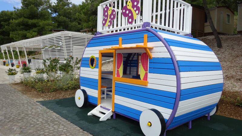 Speelhut als een stacaravan voor de kids. Vroljk geheel van kleuren blauw en wit met geel.