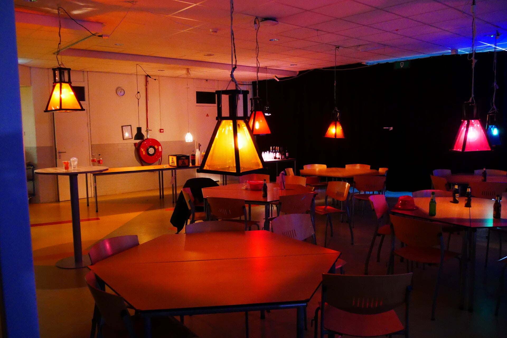 Een ruimte met lampen boven tafels, in de sfeer van rust en kalmte.