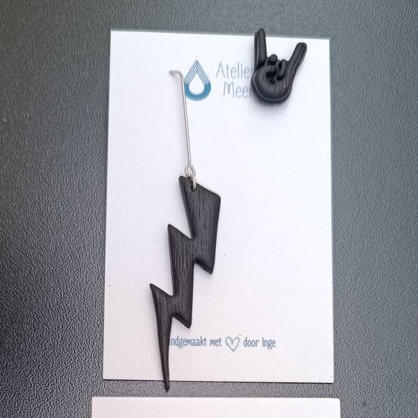 Zwarte Graspop oorbellen | metal rock hand stekertje & bliksem hanger