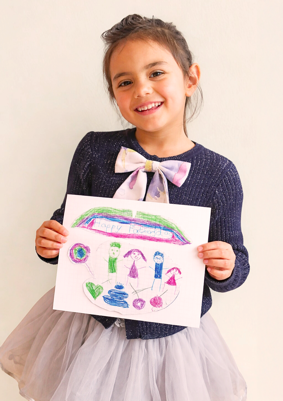 Young girl proudly holding her original Father's Day drawing, ready to be professionally restored and framed by TinyKeep Studio Malta."