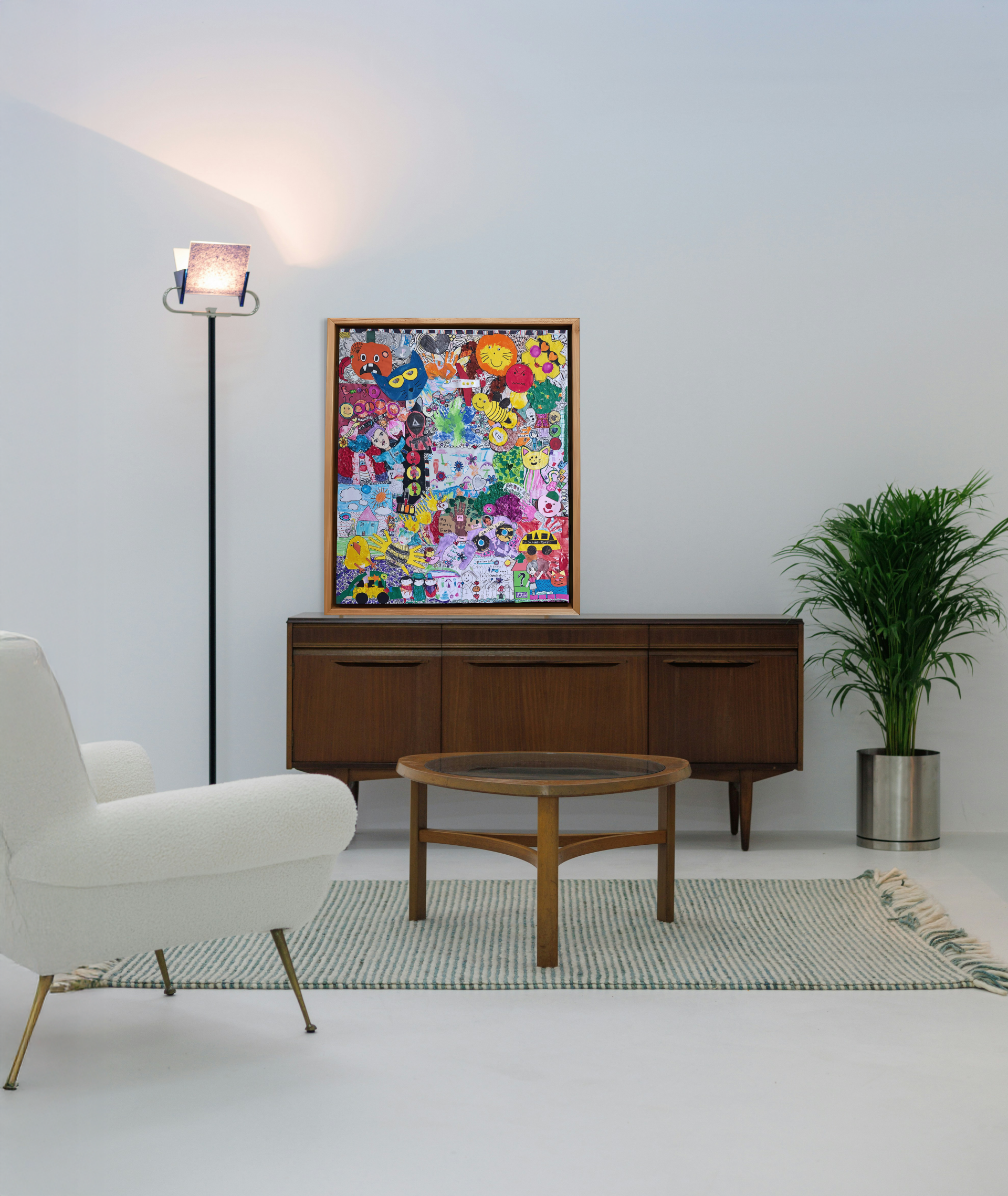 Custom kids artwork collage in a modern black frame hanging in a bright living room.