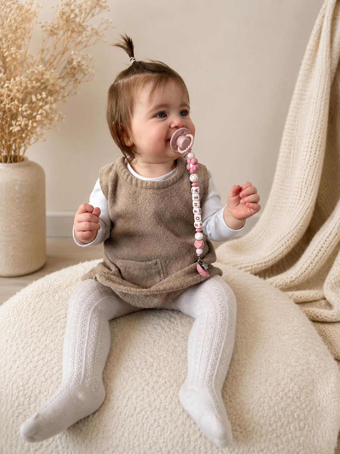 Baby met gepersonaliseerd speenkoord van CA Design in zachte beige setting