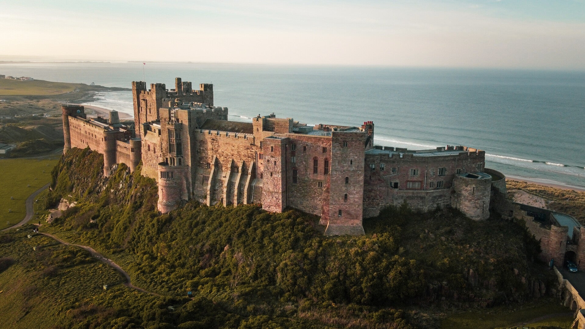 Aerial view of Bamburgh Castle above the beach and Northumberland coast