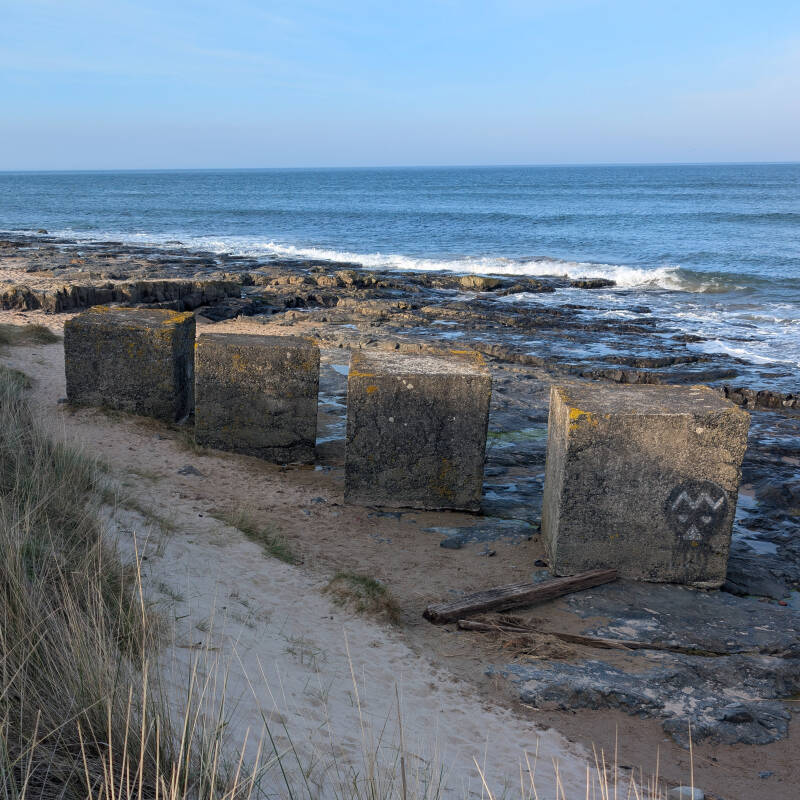 Second World War concrete anti-tank blocks beside the shore at Harkness Rocks in Bamburgh