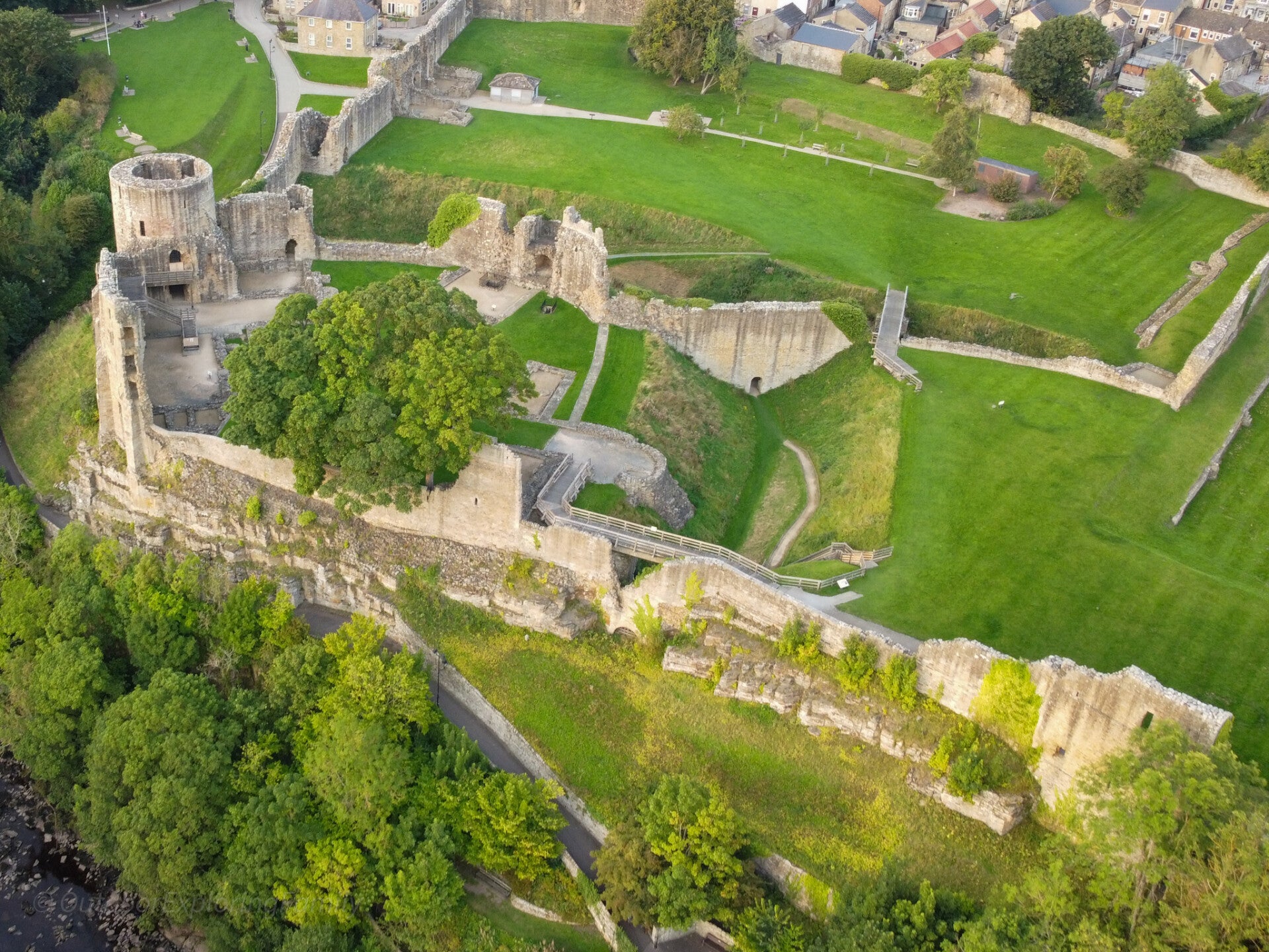Aerial view of Barnard Castle showing the Round Tower, castle wards and walls above the River Tees