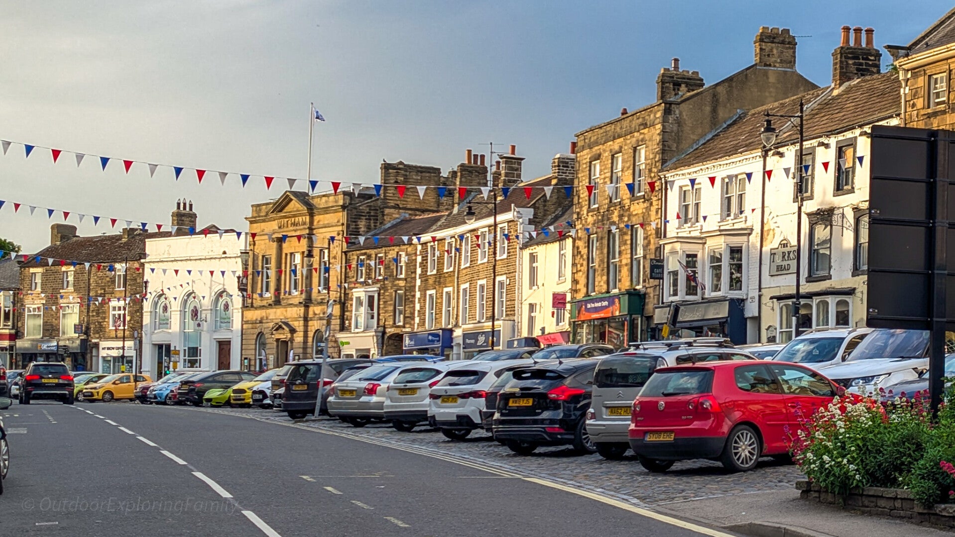 Historic Market Place in Barnard Castle town centre with traditional stone buildings, shops and bunting in Teesdale.