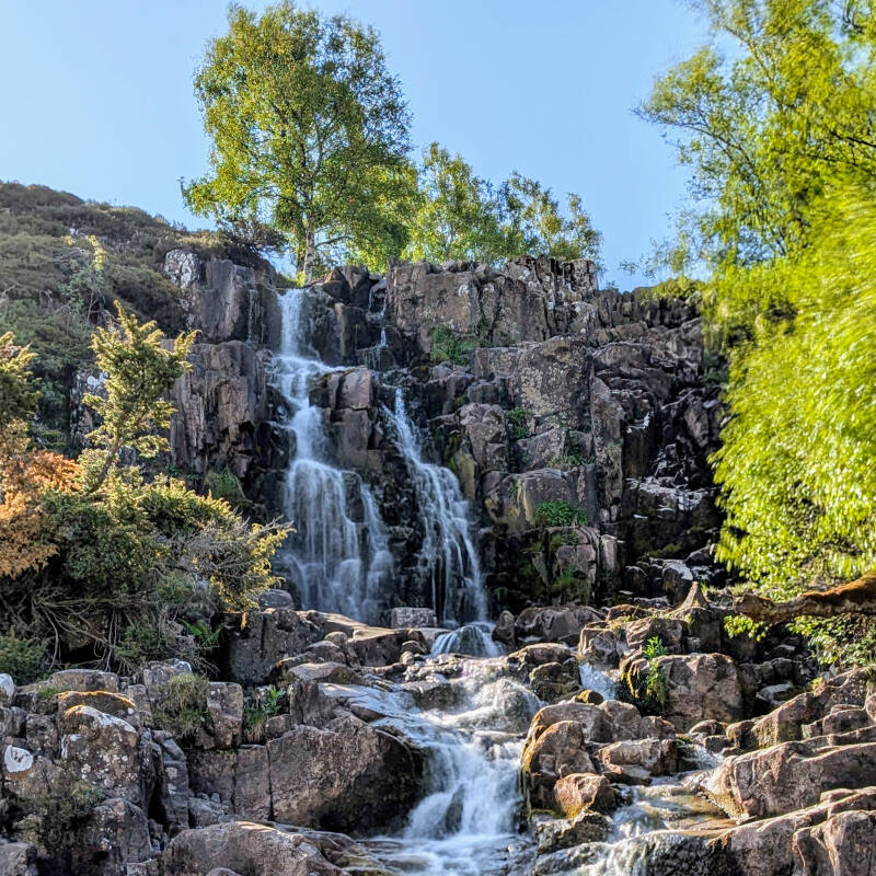 Bleabeck Force hidden waterfall in Teesdale cascading down layered rock just beyond High Force on the riverside path