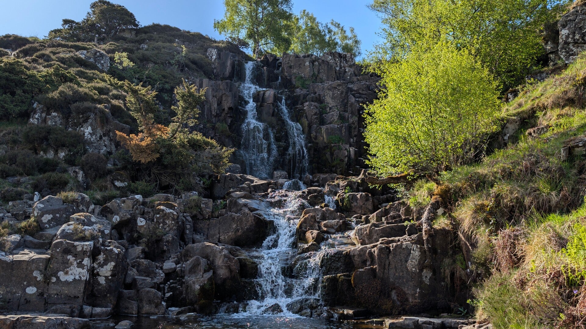 Bleabeck Force waterfall in Upper Teesdale surrounded by mossy rocks and peaceful countryside