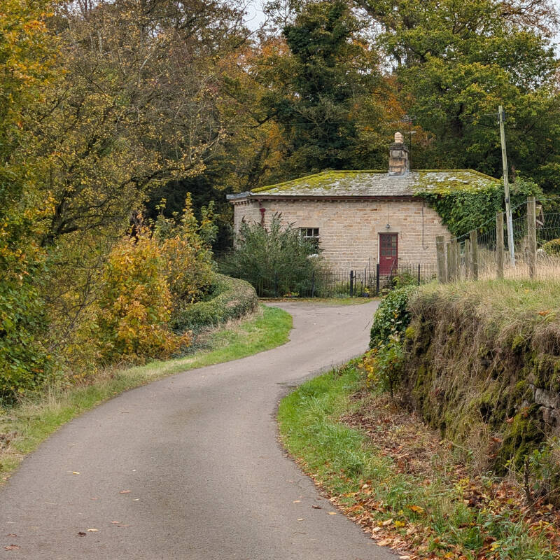 A quiet country lane winding past an old stone cottage near Dairy Bridge and Rokeby Park.