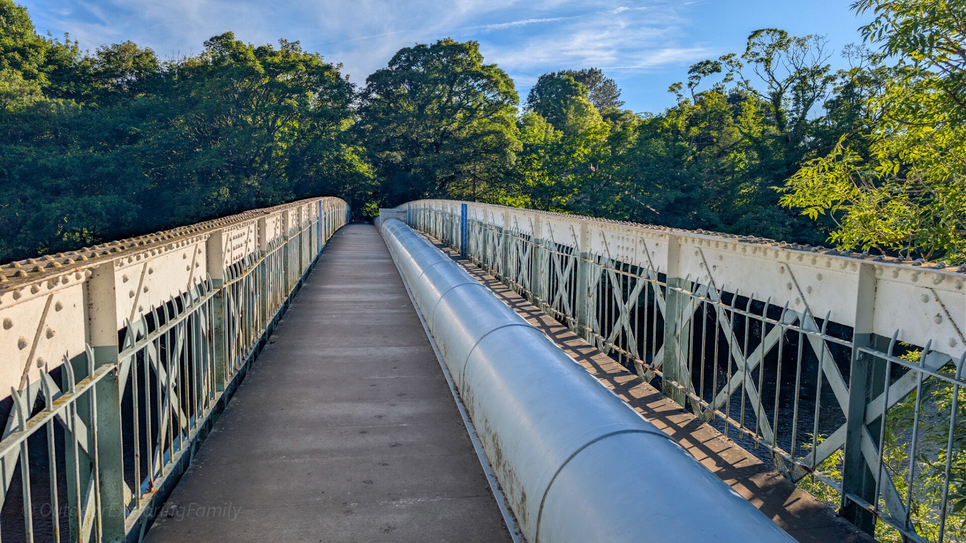 Walkway across Deepdale Aqueduct with the large water pipe running along the centre of the footbridge over the River Tees.