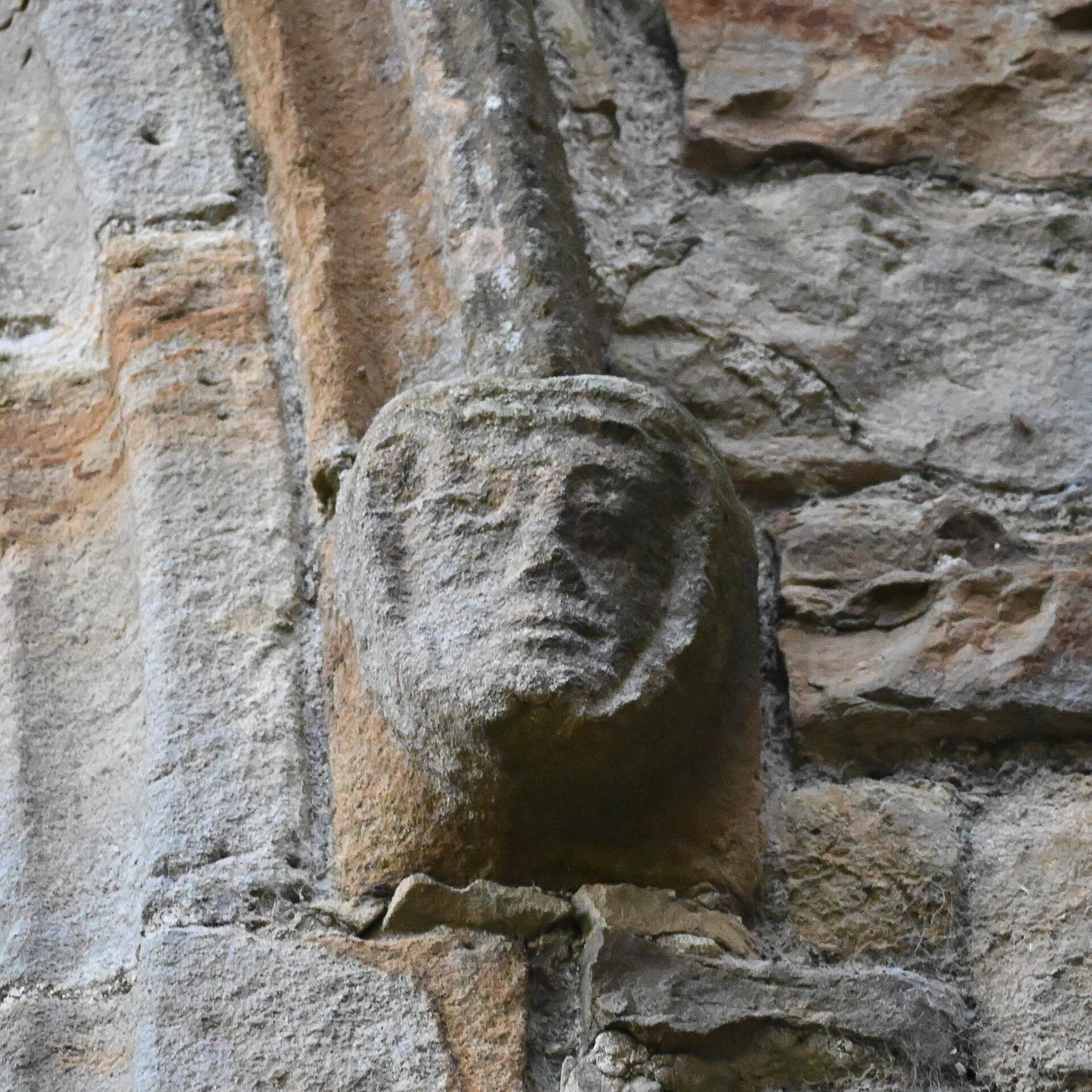 Medieval stone face carved into the ruins of Egglestone Abbey near Barnard Castle, linking to the Egglestone Abbey guide.