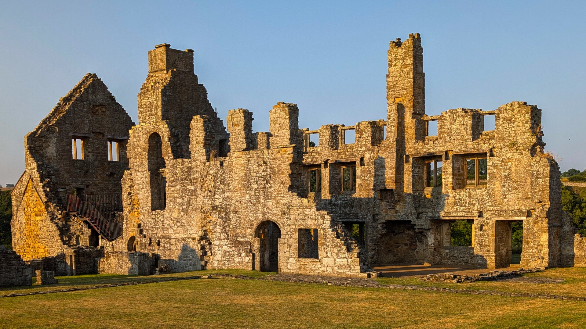 The historic stone ruins of Egglestone Abbey near Barnard Castle, glowing in the evening sunlight.