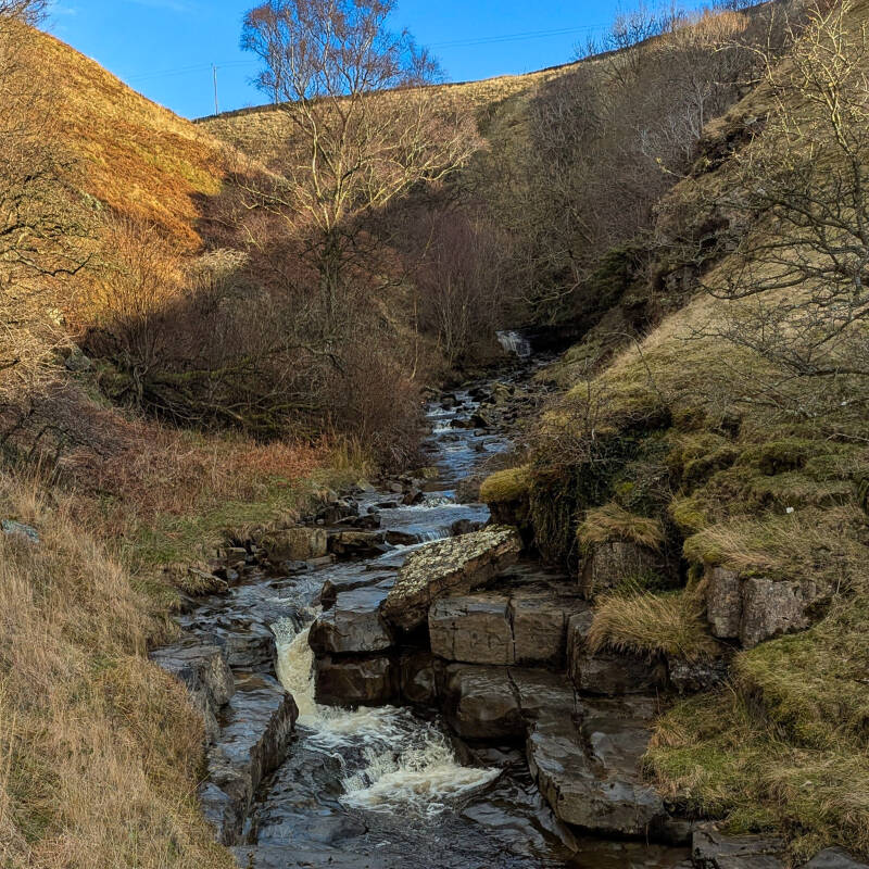 Flushiemere Beck flowing through rocky valley in Upper Teesdale with natural cascades