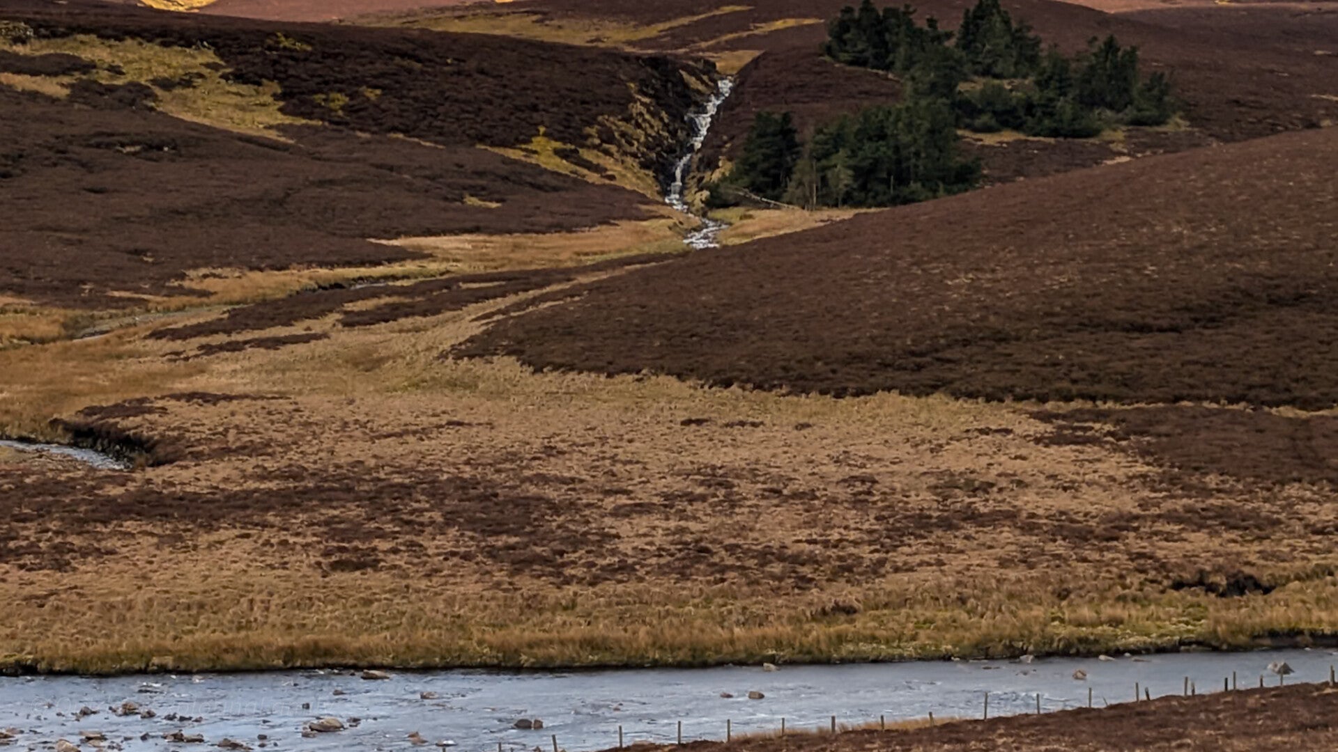 Force Burn Waterfall seen from distance with full stepped cascade visible across Upper Teesdale landscape