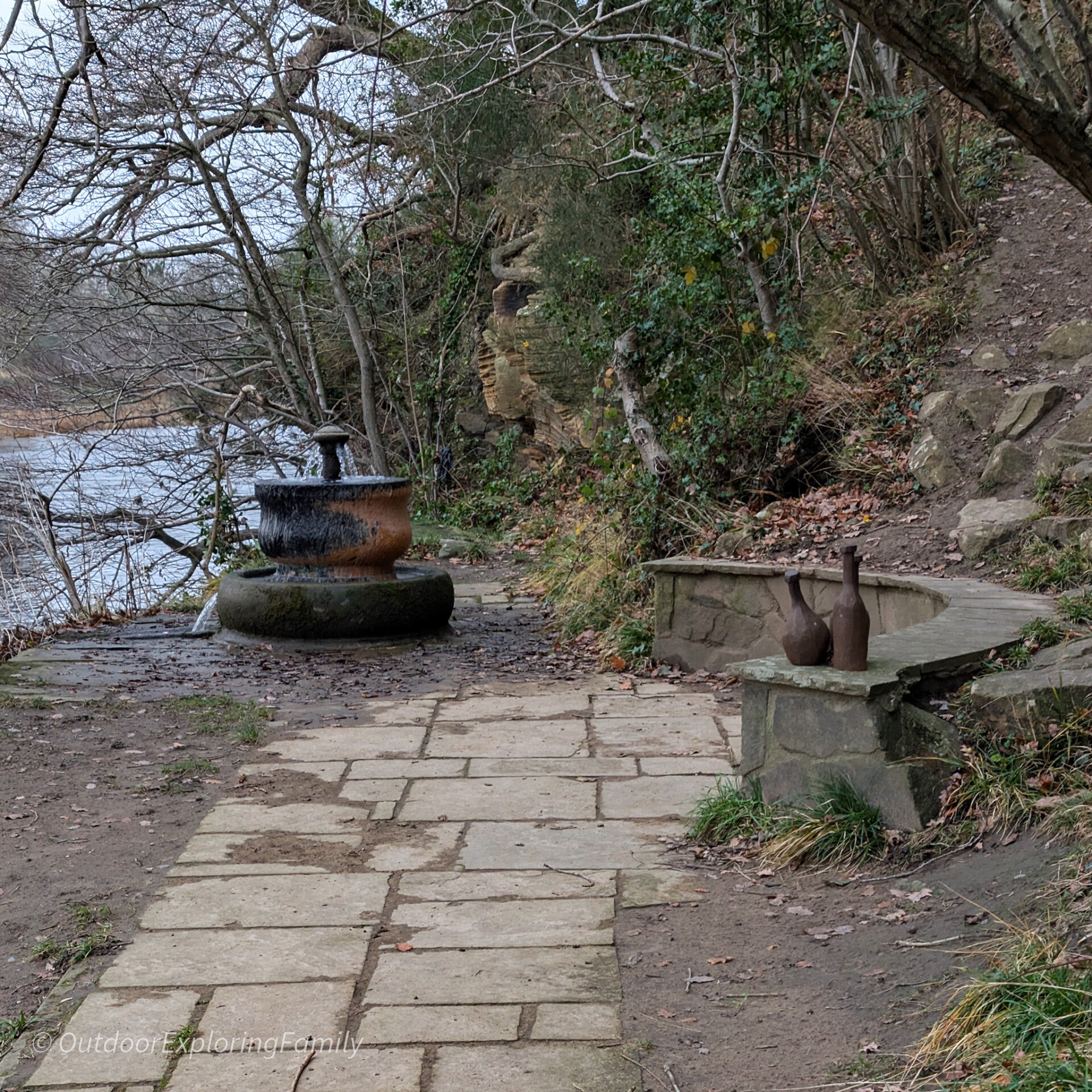 Gainford Spa sulphur spring set into stonework beside the River Tees surrounded by woodland
