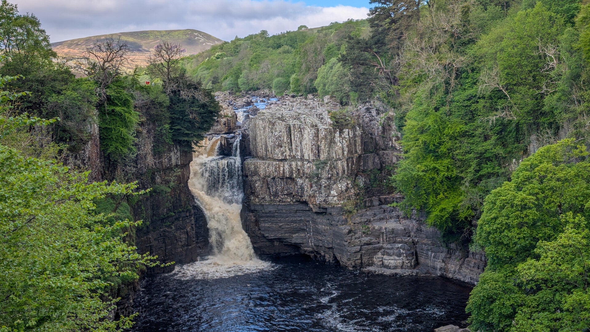 High Force Waterfall in Upper Teesdale viewed from the official viewpoint with the River Tees flowing through the rocky gorge