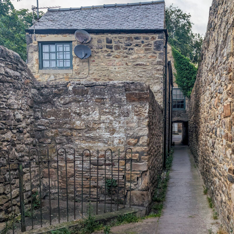 Narrow passage running beneath the Hole in the Wall building beside Queen Street car park in Barnard Castle.