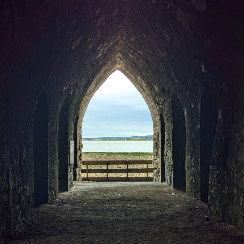View through the dark interior of the Holy Island lime kilns towards the coast and sea