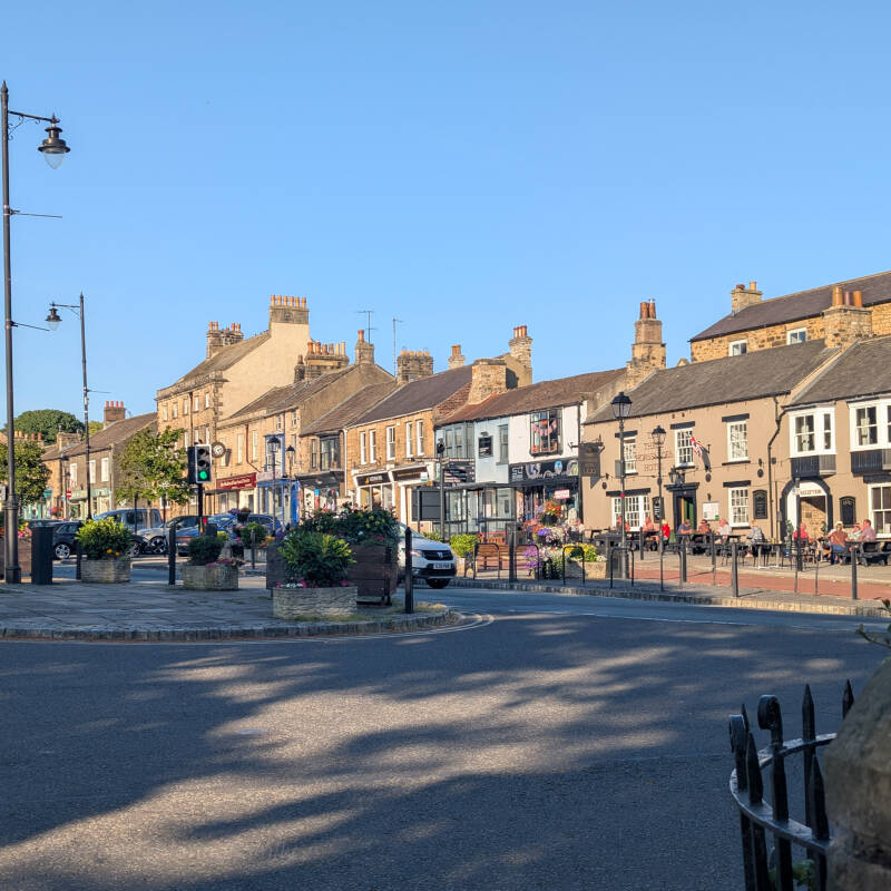 Horse Market in Barnard Castle with the Three Horseshoes Hotel, shops and historic stone buildings.