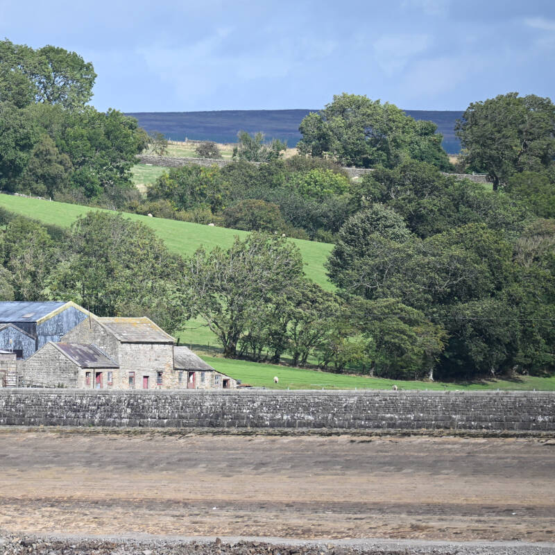Building beside the exposed shoreline of Hury Reservoir during the 2026 drawdown