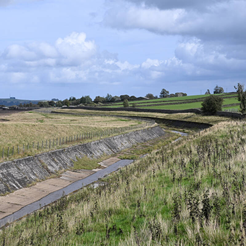 Stone lined channel and embankment exposed above the lowered water level at Hury Reservoir during the 2026 drawdown