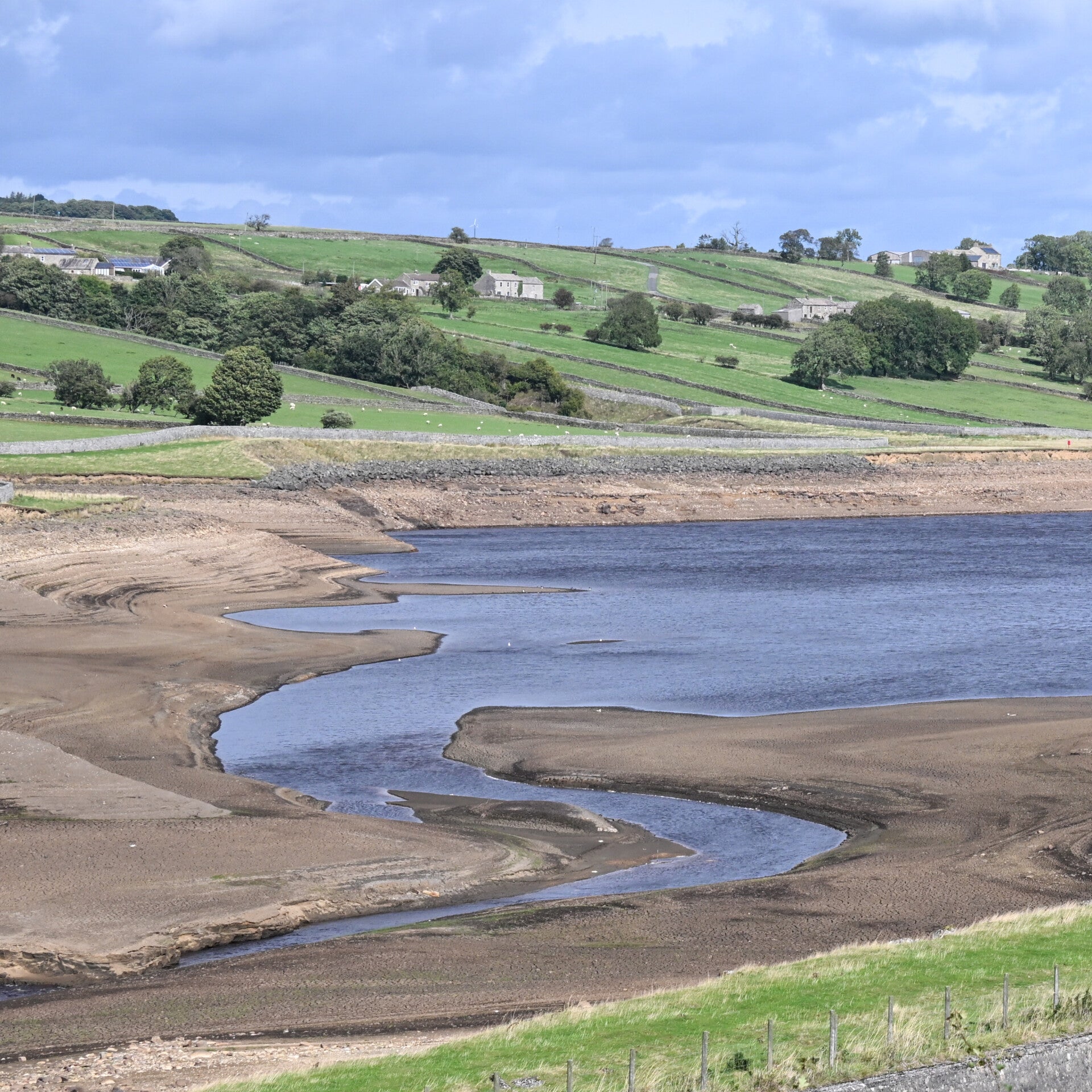 Remaining water winding through the exposed reservoir bed at Hury Reservoir during the 2026 drawdown