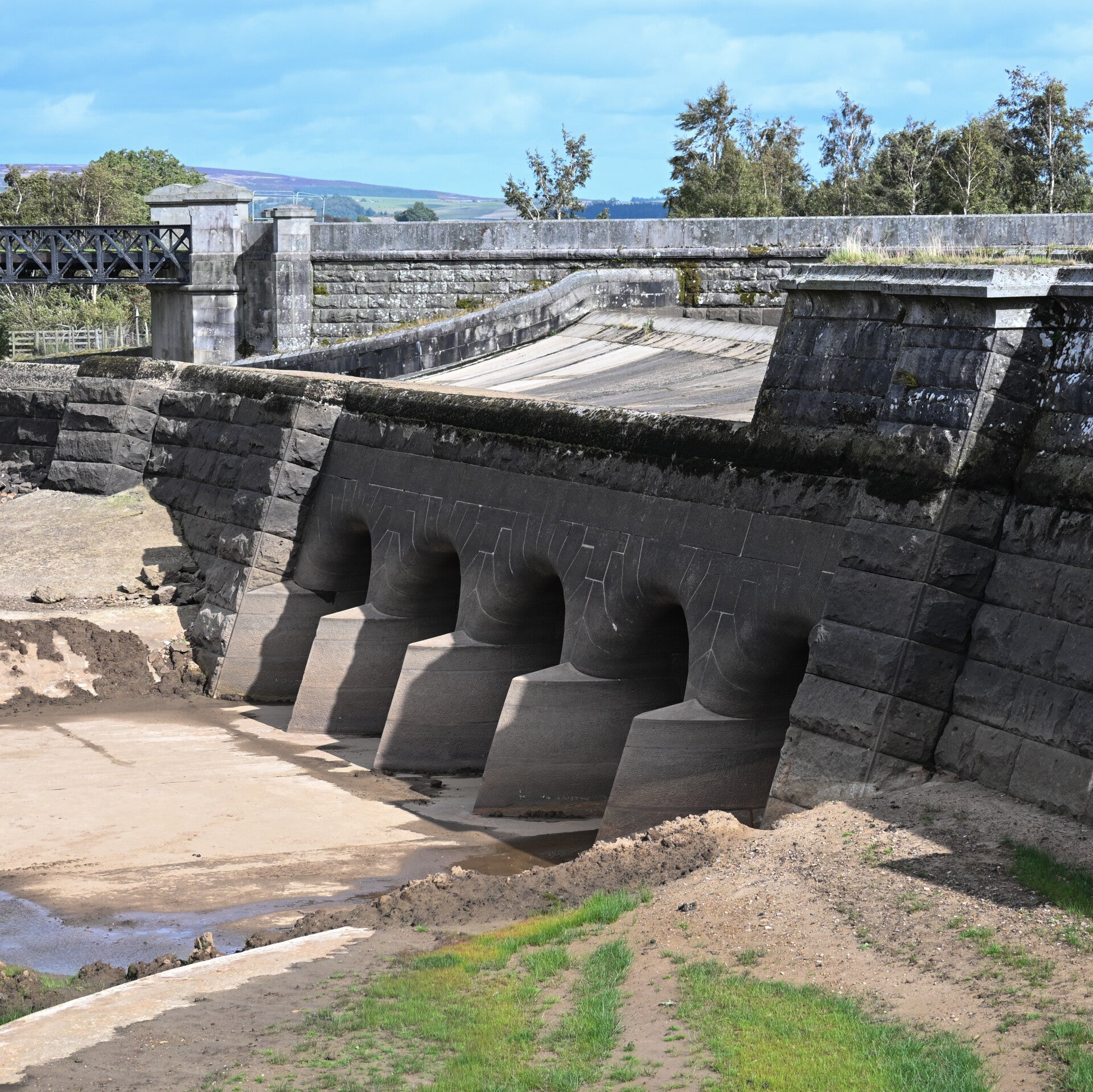 Stone spillway structure exposed above the low water at Hury Reservoir during the 2026 improvement works