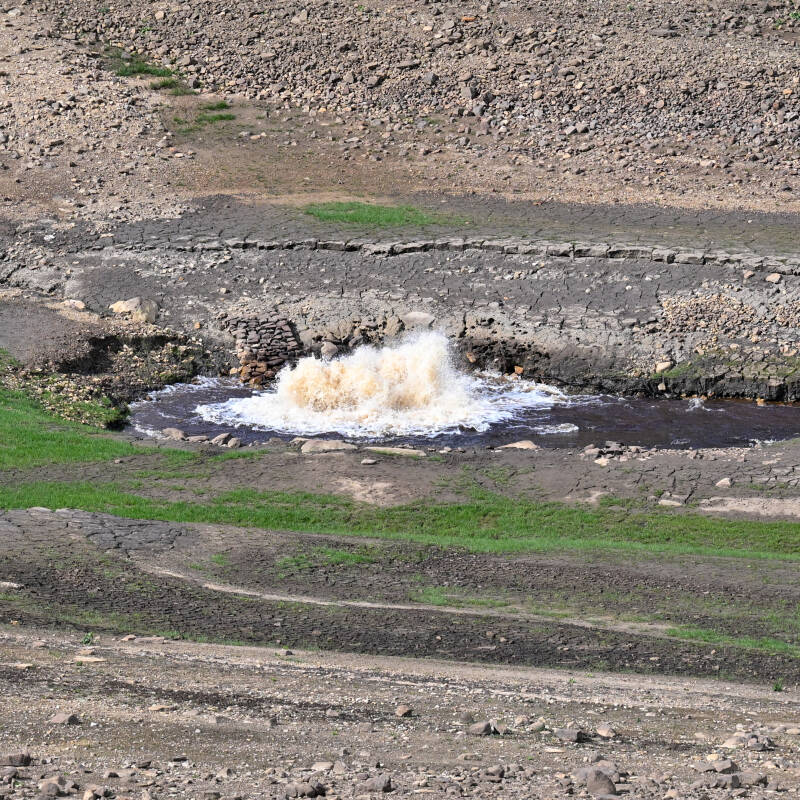 Water flowing through the exposed reservoir bed at Hury Reservoir during the 2026 drawdown