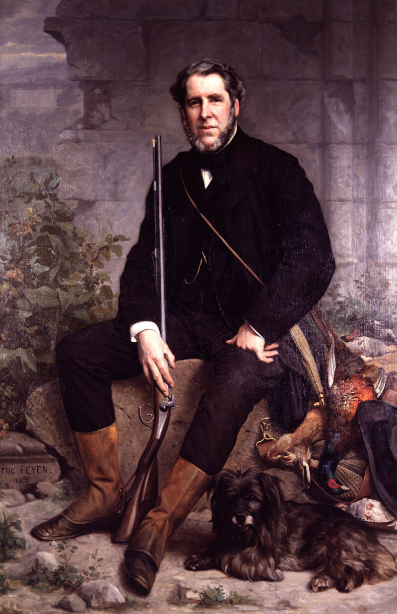 A classical oil painting depicting a seated man dressed in dark hunting attire with brown boots, holding a rifle, accompanied by a small black dog lying at his feet. The background features a stone wall and a dead fox and birds, highlighting themes of hun