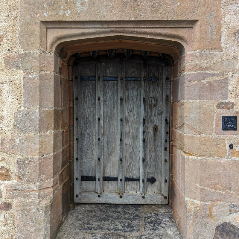 Historic wooden entrance door set into the stone walls of Lindisfarne Castle