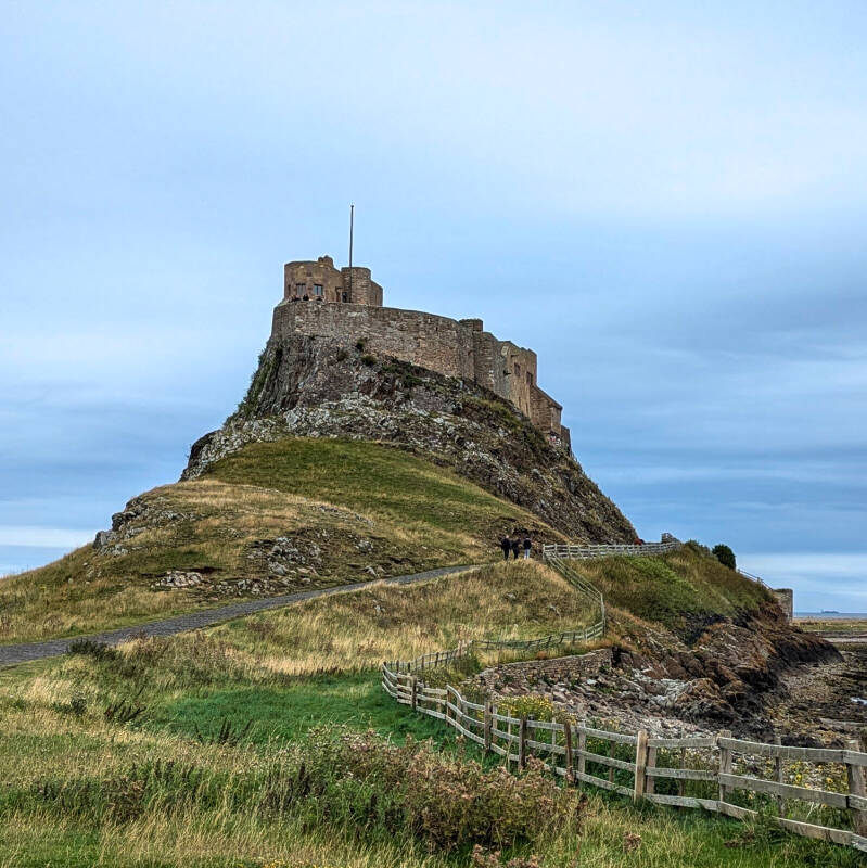 Lindisfarne Castle overlooking the harbour and boats on Holy Island