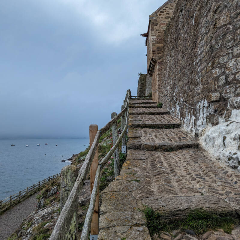 Cobbled approach beside Lindisfarne Castle looking down towards the Holy Island coastline
