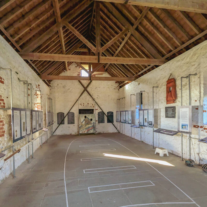 Inside Holy Island Lifeboat Museum with historic displays and the outline of the Lizzie Porter lifeboat marked on the floor.