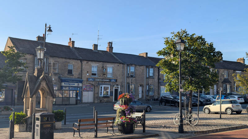 Wide view across the lower end of Galgate from Barnard Castle Market Place, with the Coach and Horses and surrounding stone buildings.