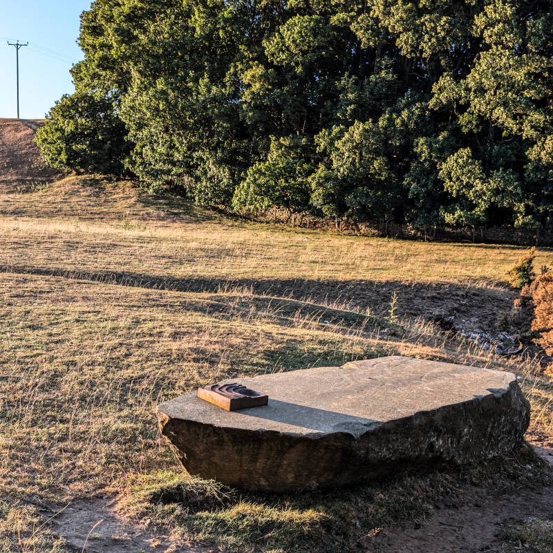 Small cast-metal viewpoint marker on a stone plinth at the Meeting of the Waters in Teesdale