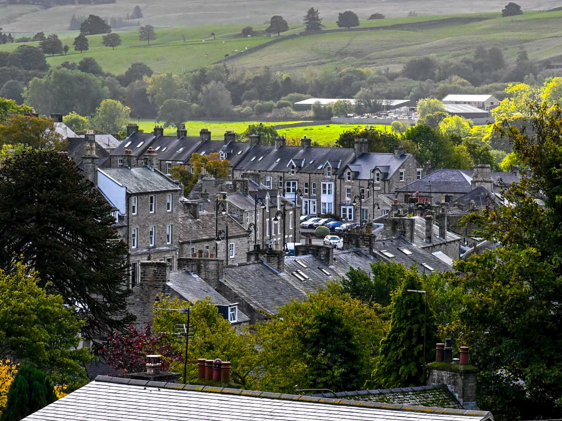 View across the stone rooftops of Middleton-in-Teesdale towards the green hills, photographed from the King's Walk path above Hude.