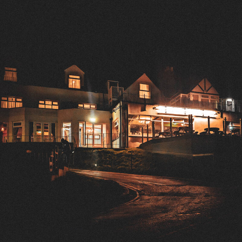 Buildings lit up beside Seahouses Harbour during an evening walk