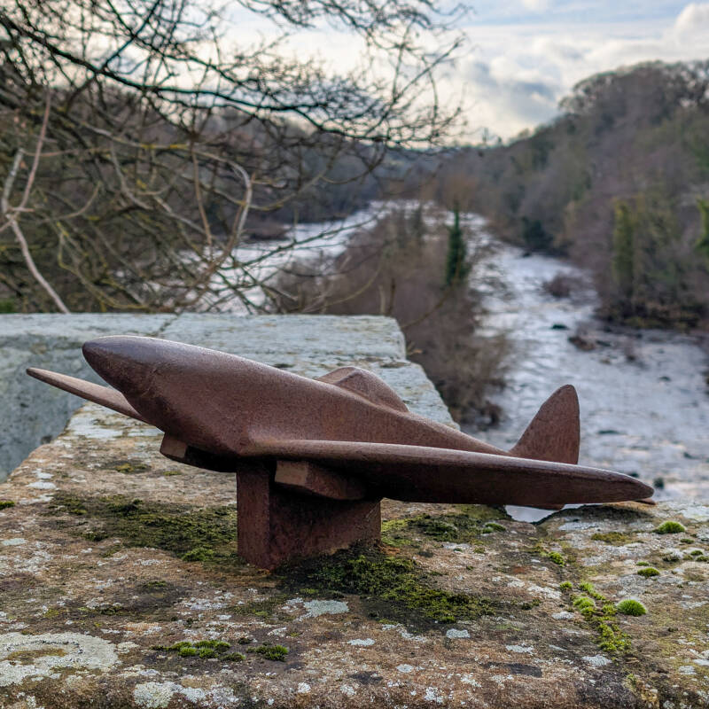 Model Spitfire on Winston Bridge above the River Tees marking the famous 1988 flight beneath the bridge during filming in Teesdale