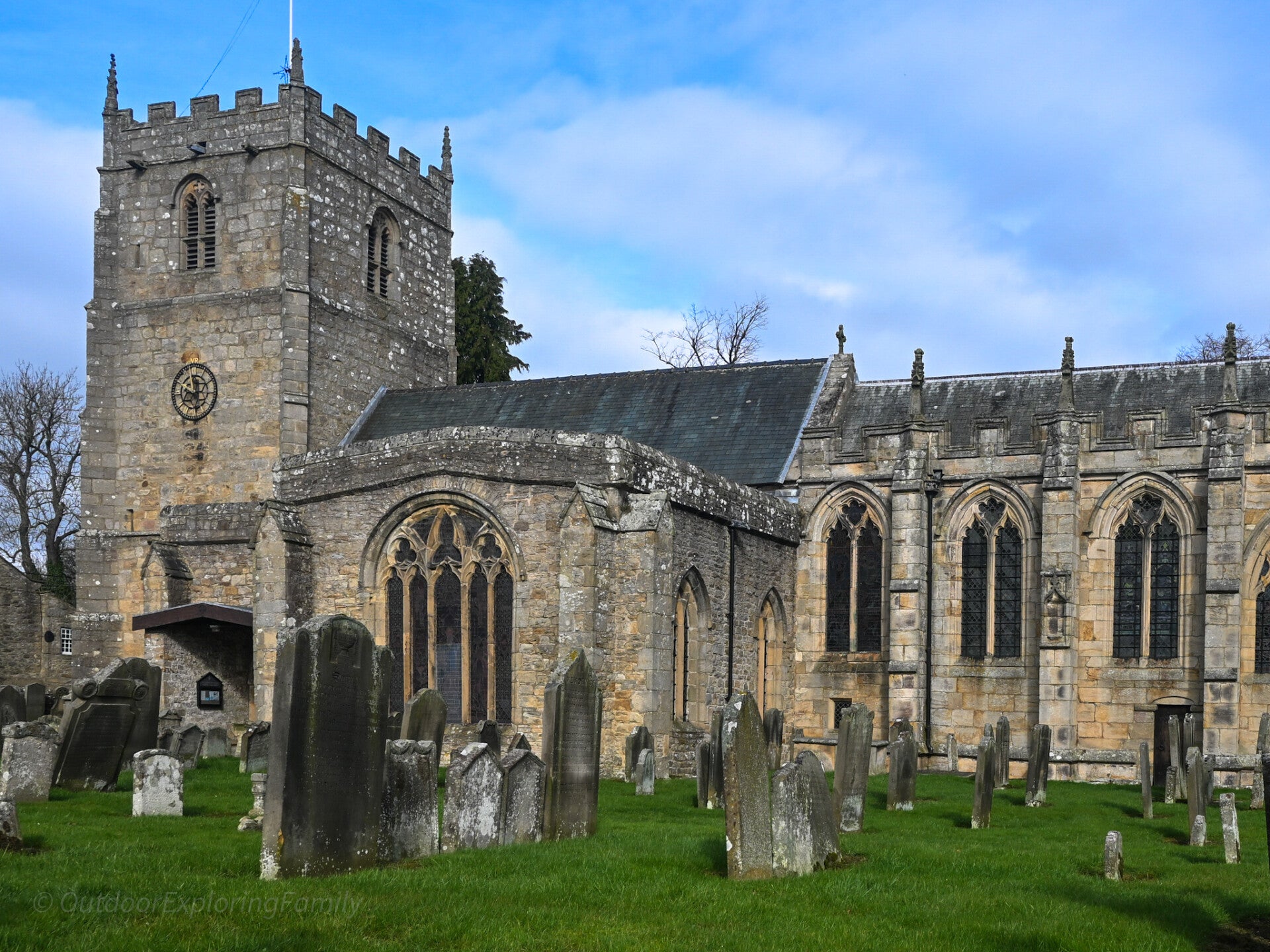 St Romald’s Church in Romaldkirk, Teesdale, showing historic stone tower, Gothic windows and gravestones in the churchyard